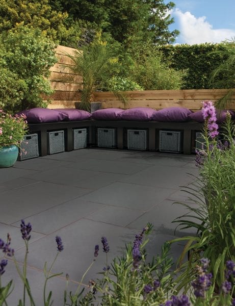 Sandstone in dark grey paving with purple lavender and seating area